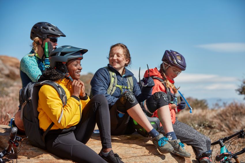 Group of Scouts wearing helmets resting together during a biking trip