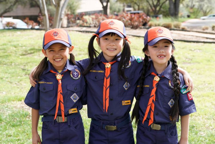 Three girl Cub Scouts in uniform.