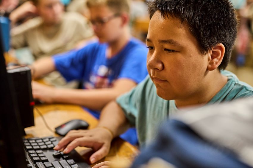 A Scout participates in a hands-on computer activity while working toward a technology merit badge—part of Scouting America’s new focus on digital skills and future-ready learning.