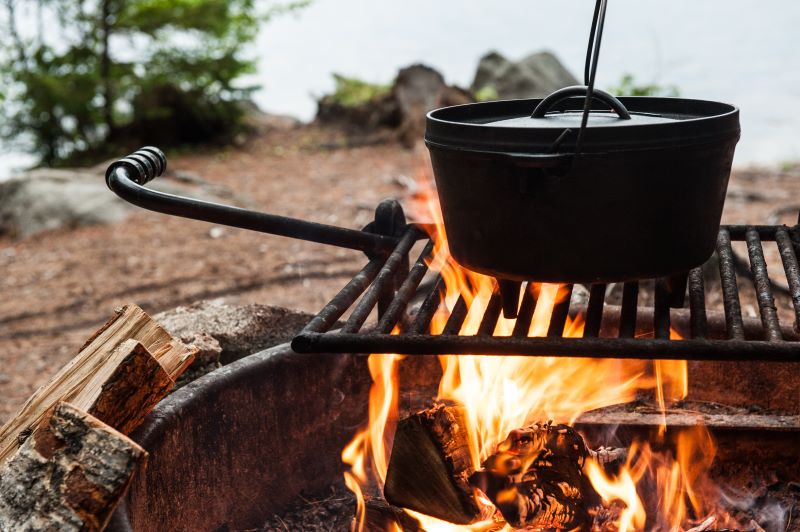 Dutch oven on a rack over a campfire. 